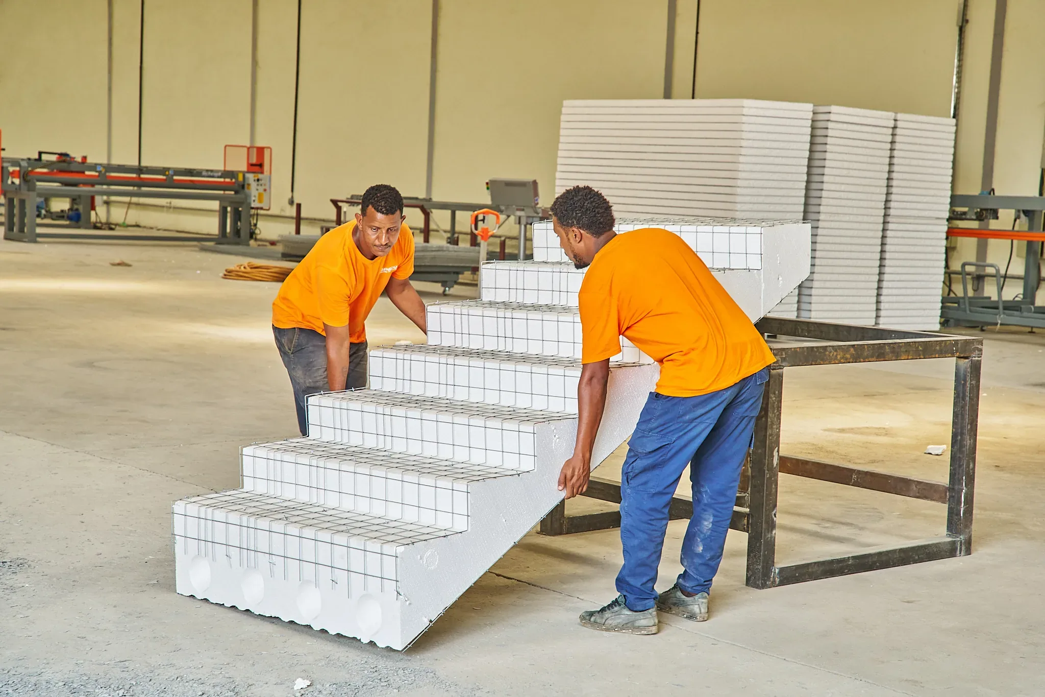 Workers handling a SPECO EPS staircase element at the factory in Juba