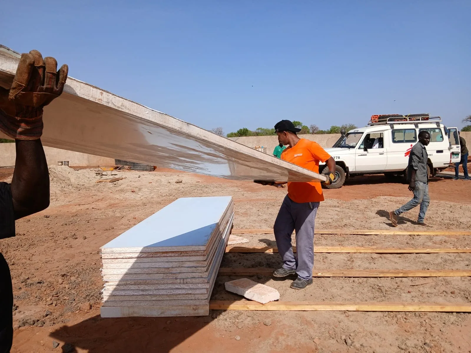 MSF warehouse, Tujur: crew carrying a sandwich panel